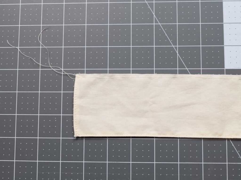 Long stitches at the top of a piece of fabric for ruffling