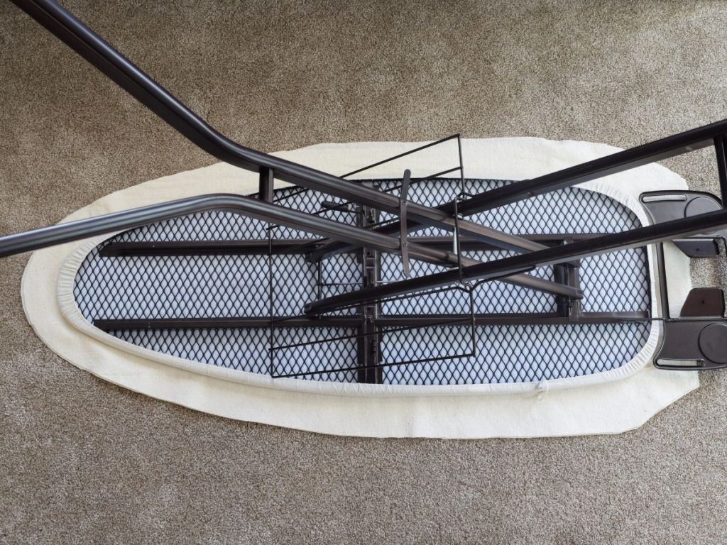 ironing board flipped upside down on batting that has been trimmed to mimic the shape