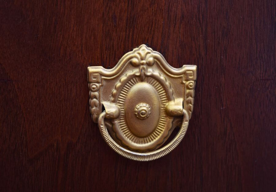 a gold dresser handle on a wood dresser