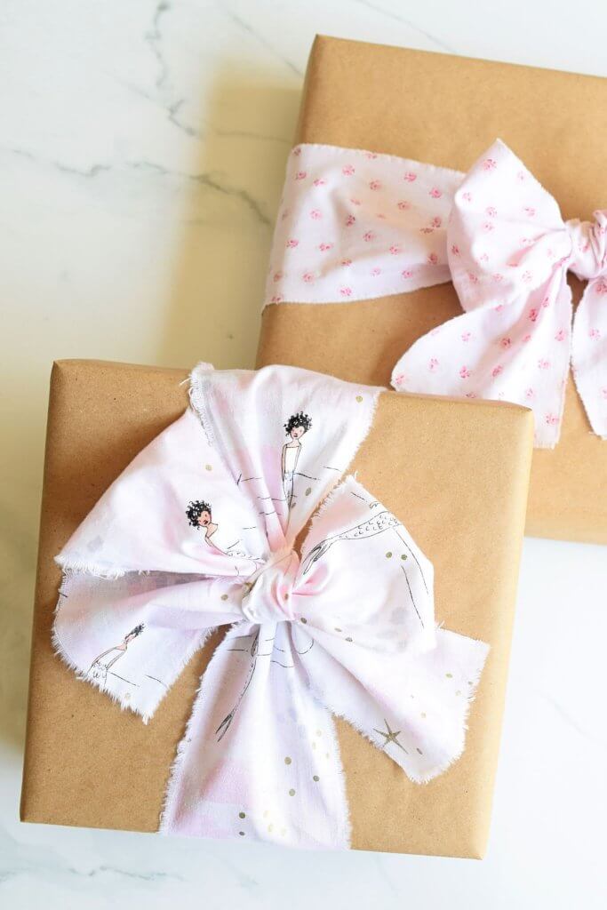 gifts wrapped in brown paper and tied with fabric ribbon bows
